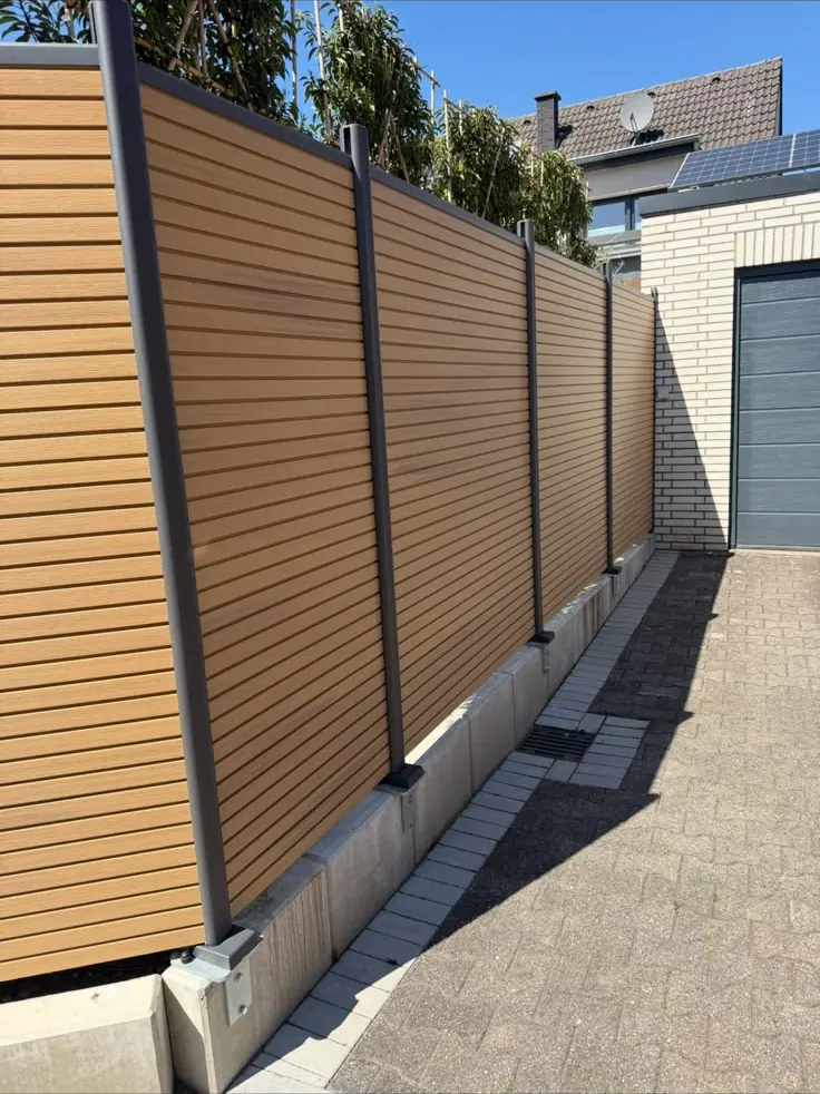 Sichtschutzzaun aus Holz entlang einer Grundstücksgrenze